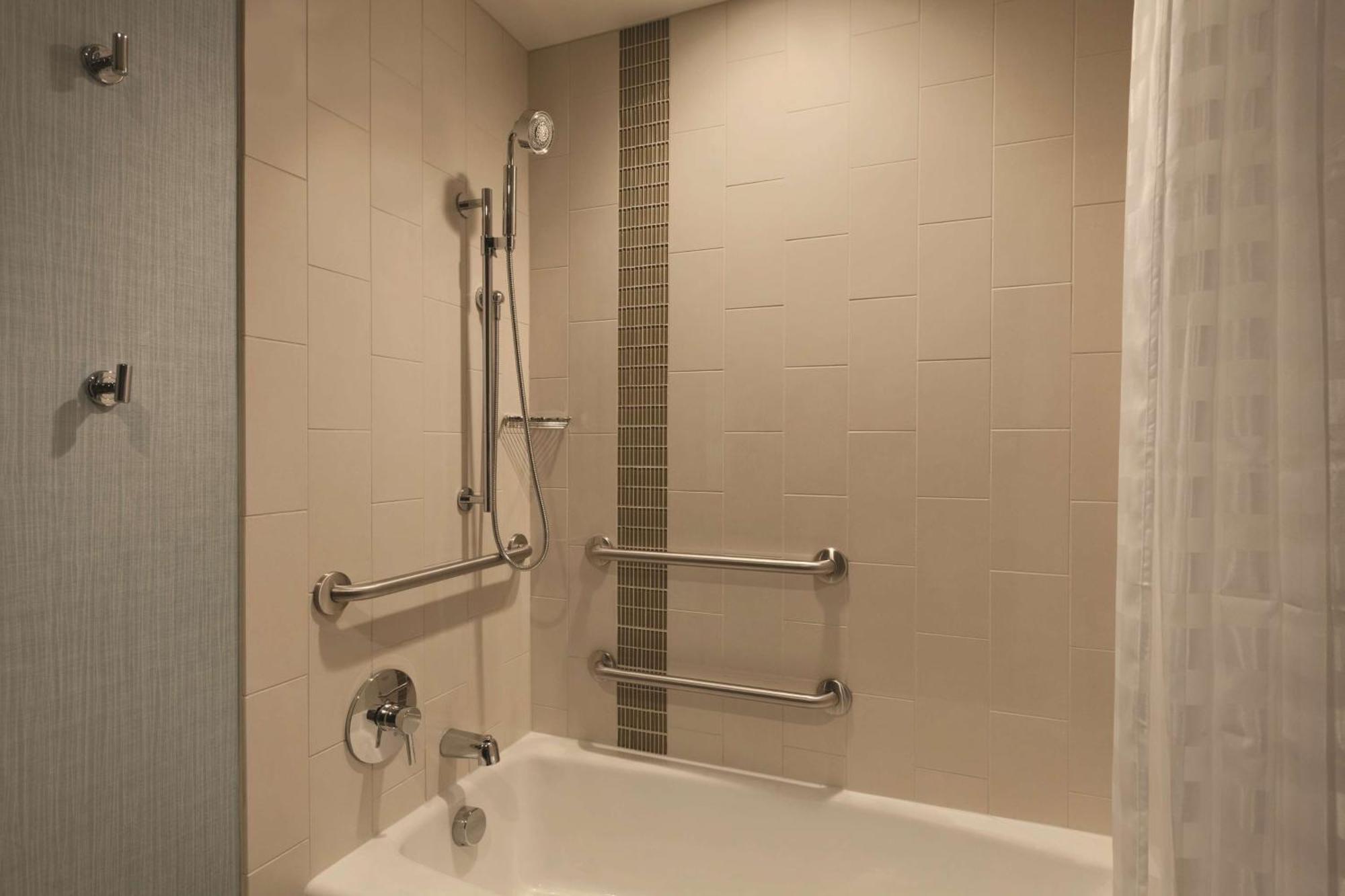 Chambre Lit King-Size pour Personnes à Mobilité Réduite avec Canapé-Lit et Baignoire Adaptée