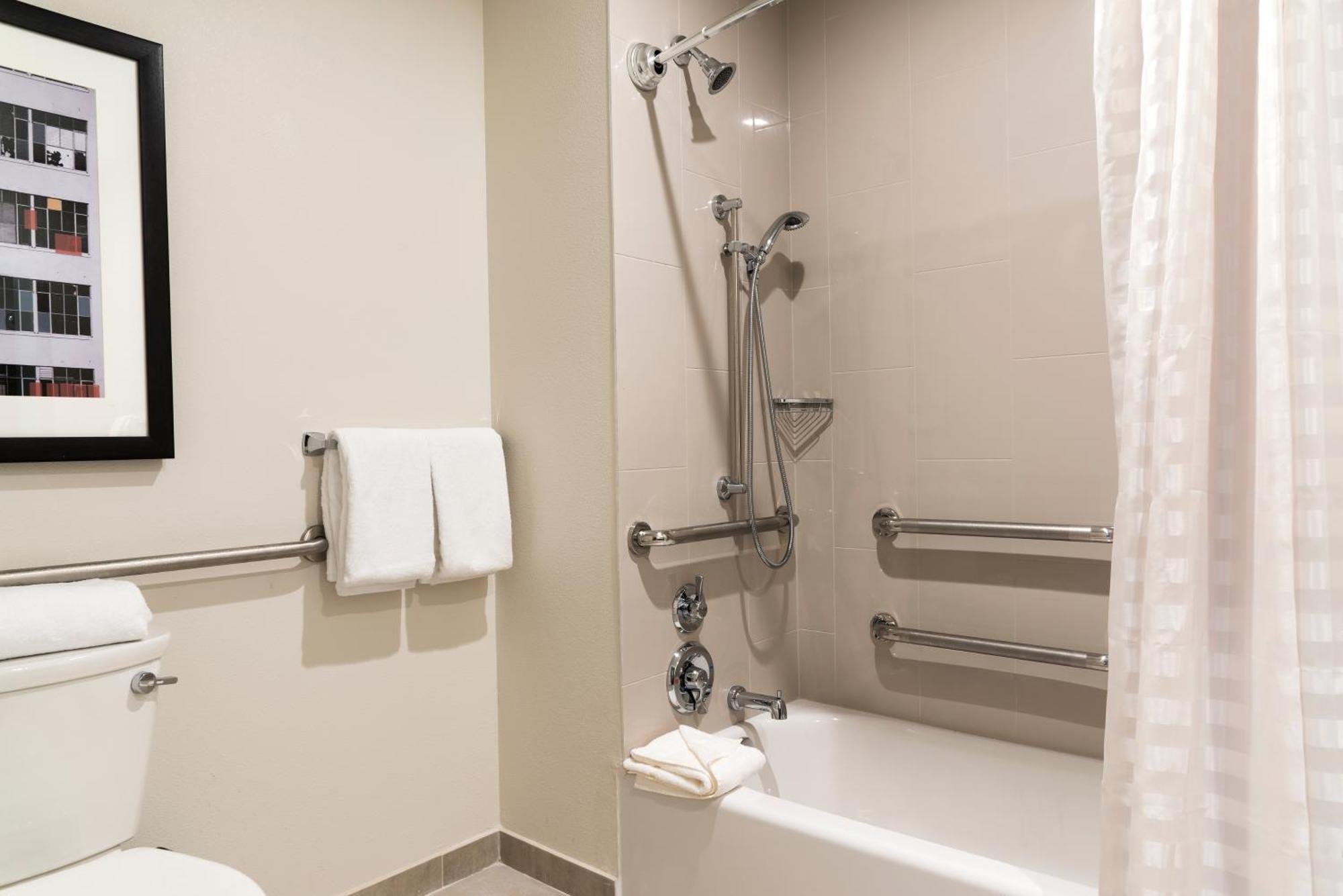 Habitación con cama extragrande y bañera adaptada para personas de movilidad reducida