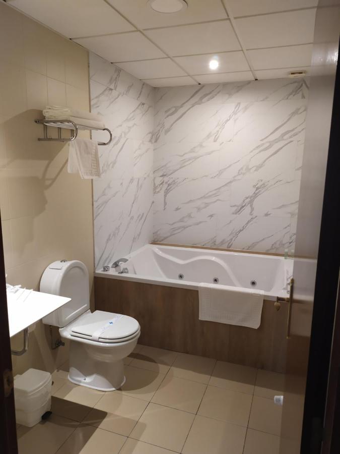 Habitación con cama grande y bañera de hidromasaje