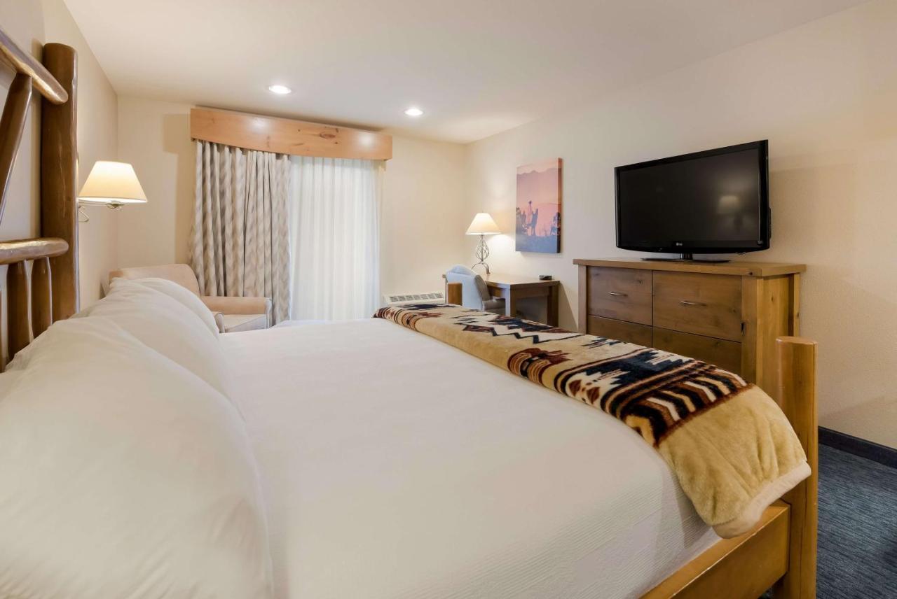 Nichtraucher Suite mit Kingsize-Bett und Blick auf die Stadt.