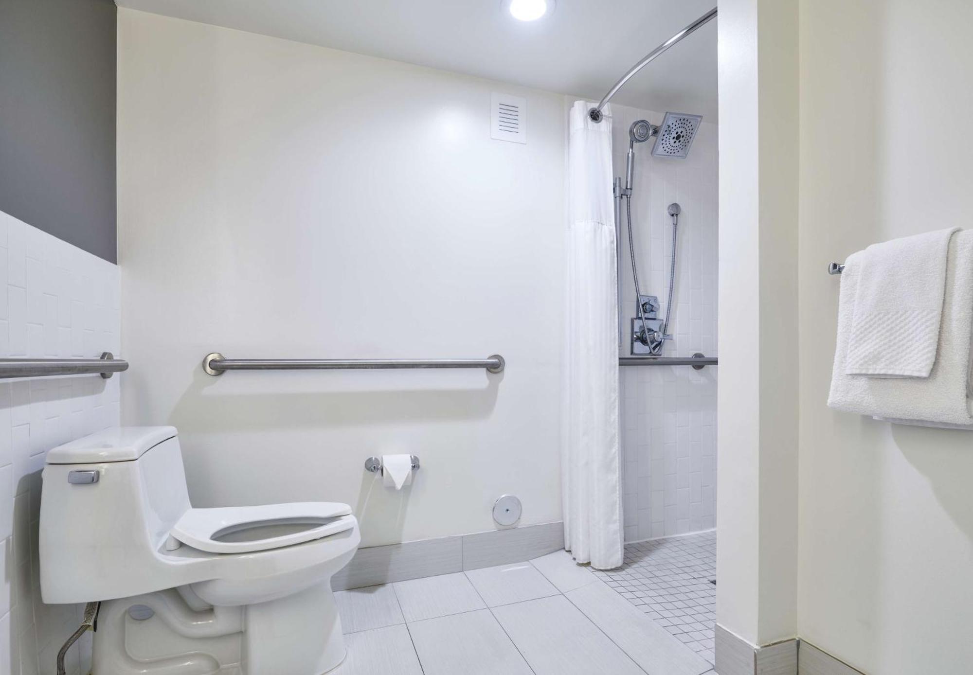 Habitación adaptada para personas de movilidad reducida con cama extragrande y ducha a ras de suelo