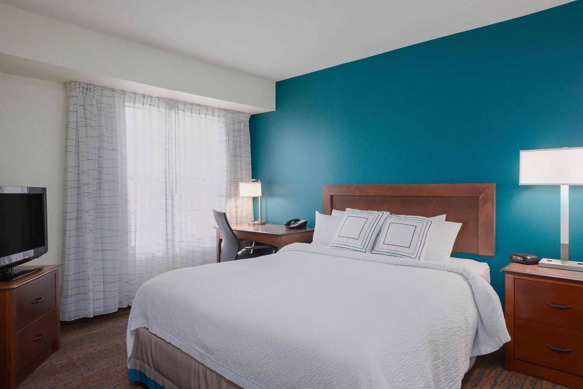 Suite con cama extragrande, sofá cama y vistas a la ciudad