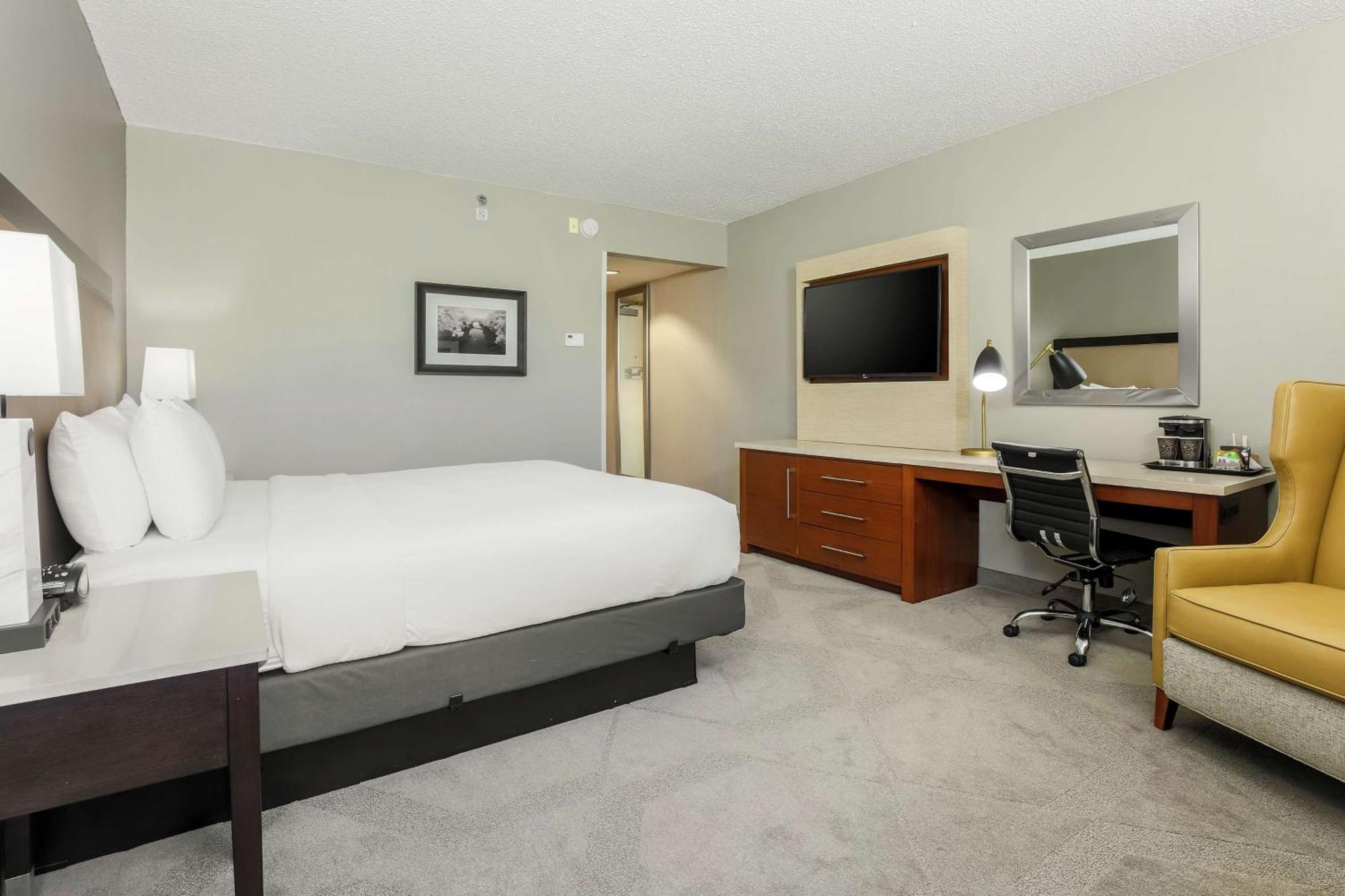 Nichtraucher Suite mit Kingsize-Bett und Blick auf die Stadt.