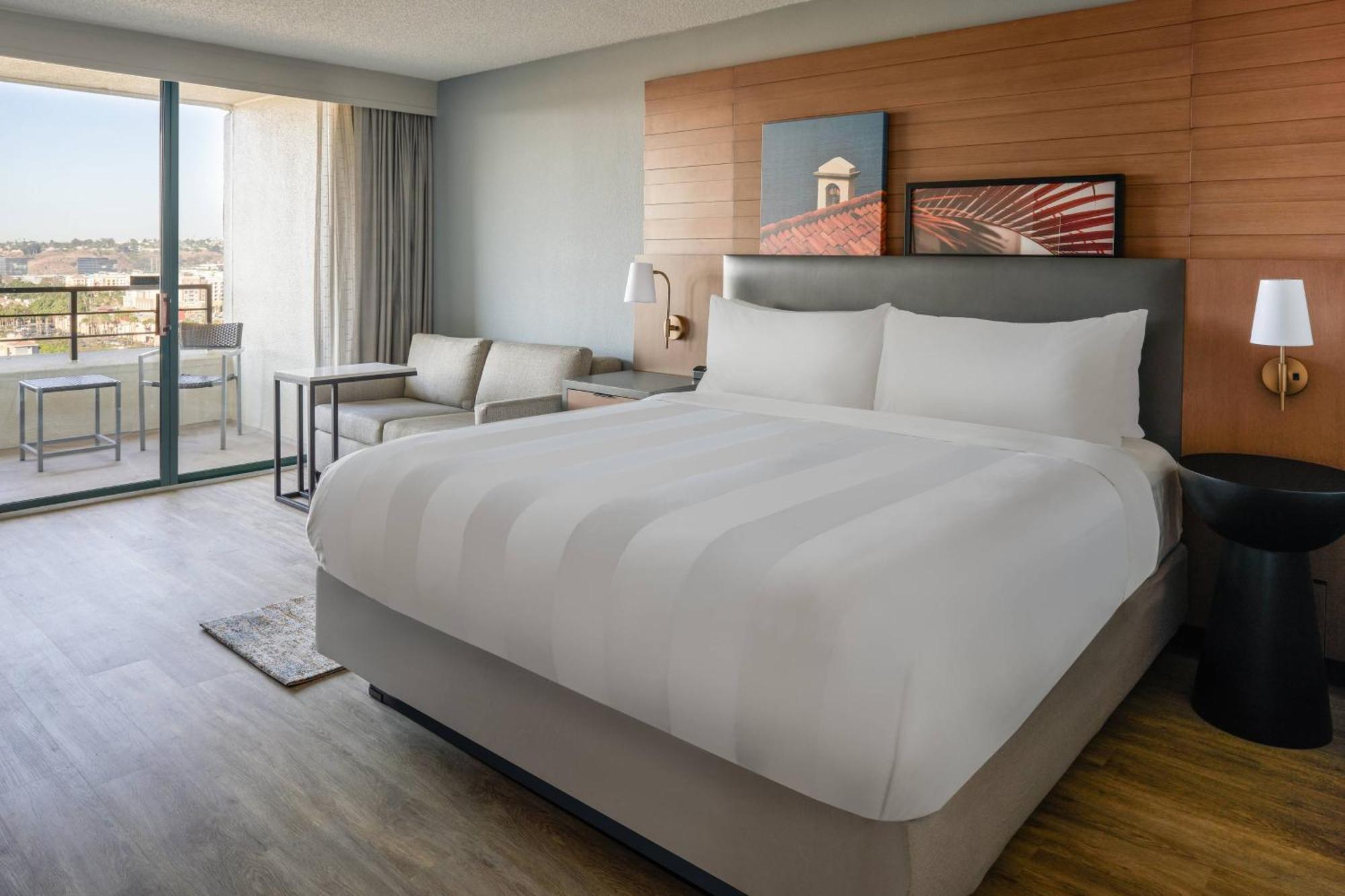 Habitación con cama extragrande, balcón y vistas a la piscina