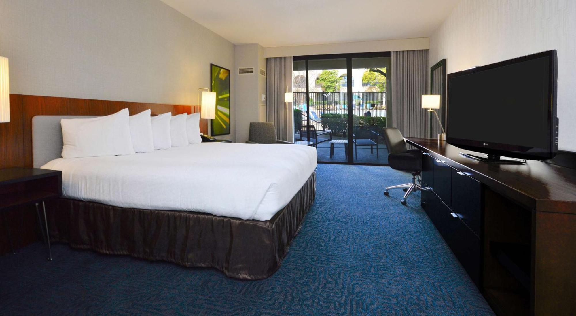 Zimmer mit Kingsize-Bett und Poolblick