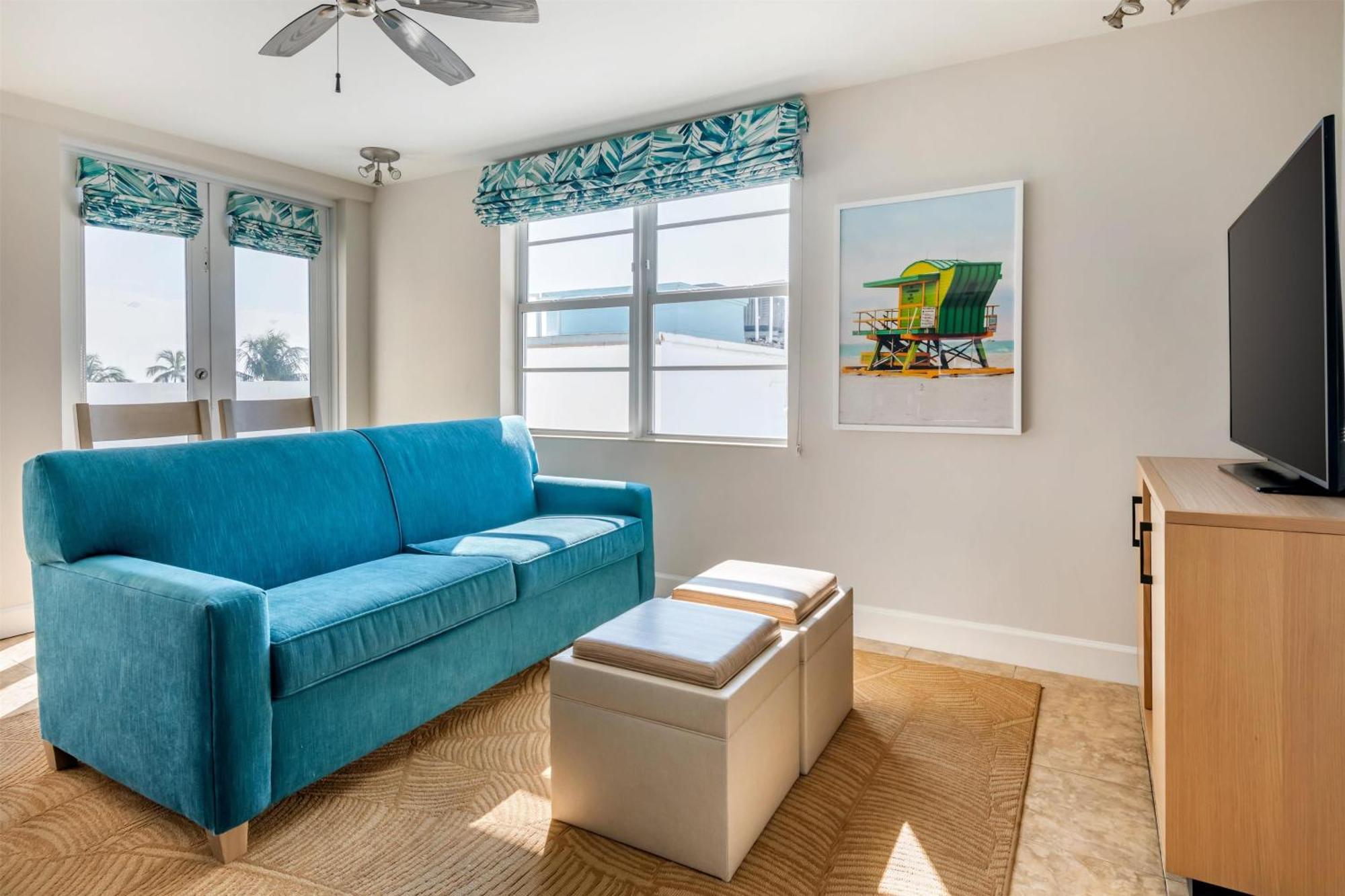 Suite de 1 dormitorio con cama grande, sofá cama y vistas al mar