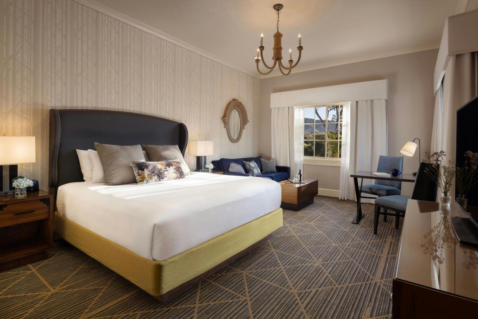 Habitación con cama extragrande, sofá cama y vistas parciales al río