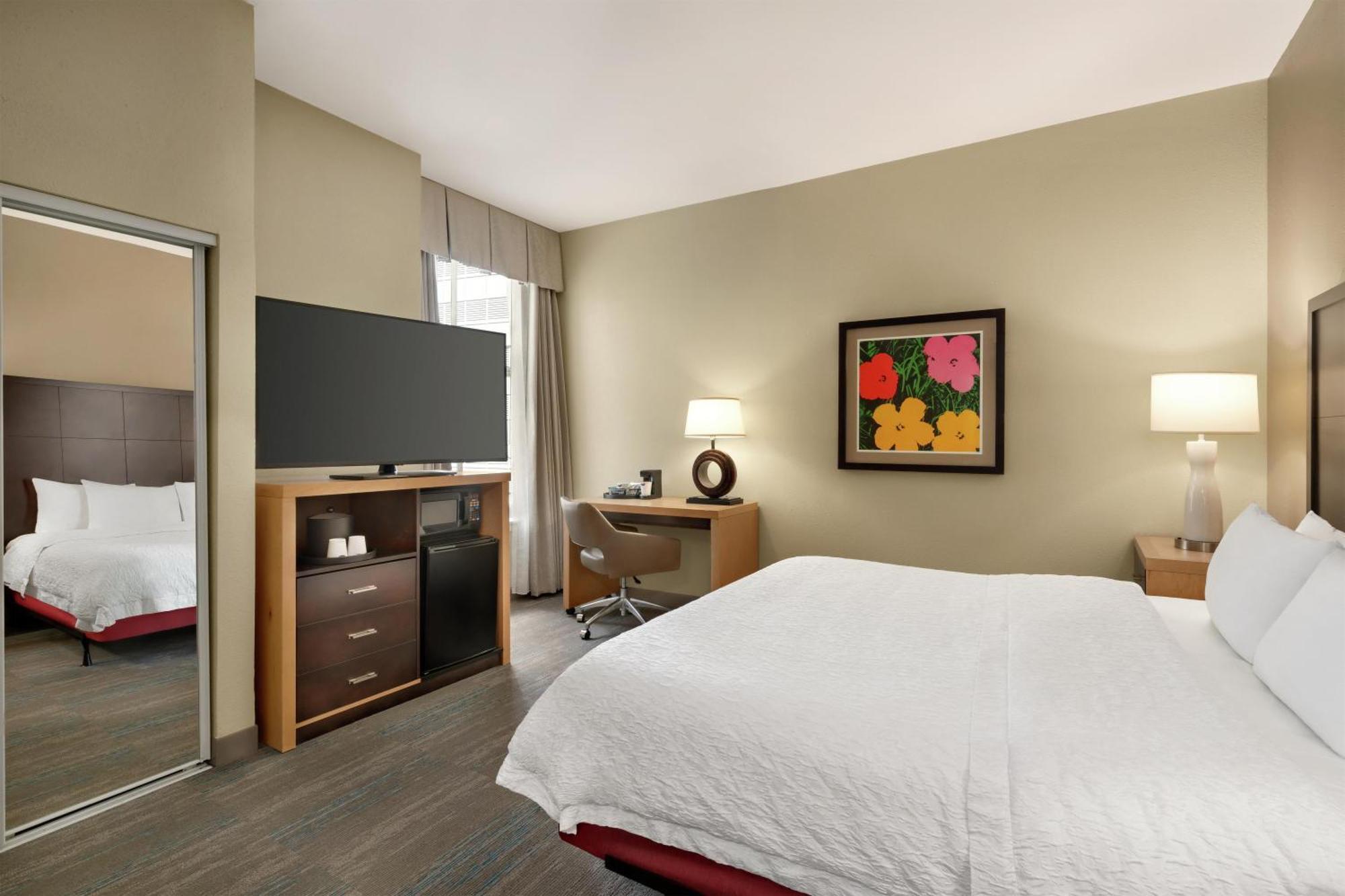 Habitación con cama extragrande y bañera adaptada para personas con movilidad reducida